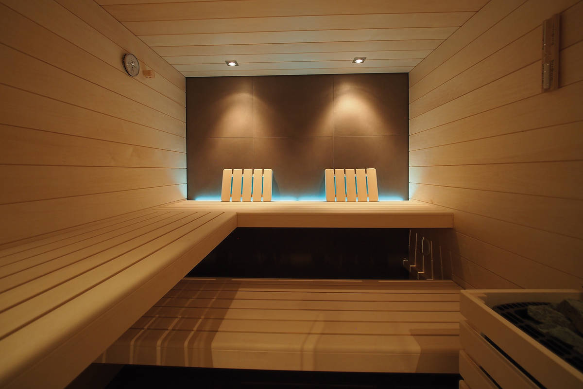 Das Spezielle an dieser Sauna in Espe mit Ganzglasfront ist die Akzentbeleuchtung an der rückwärtigen Innenwand. Sanatherm-Saunabau GmbH.