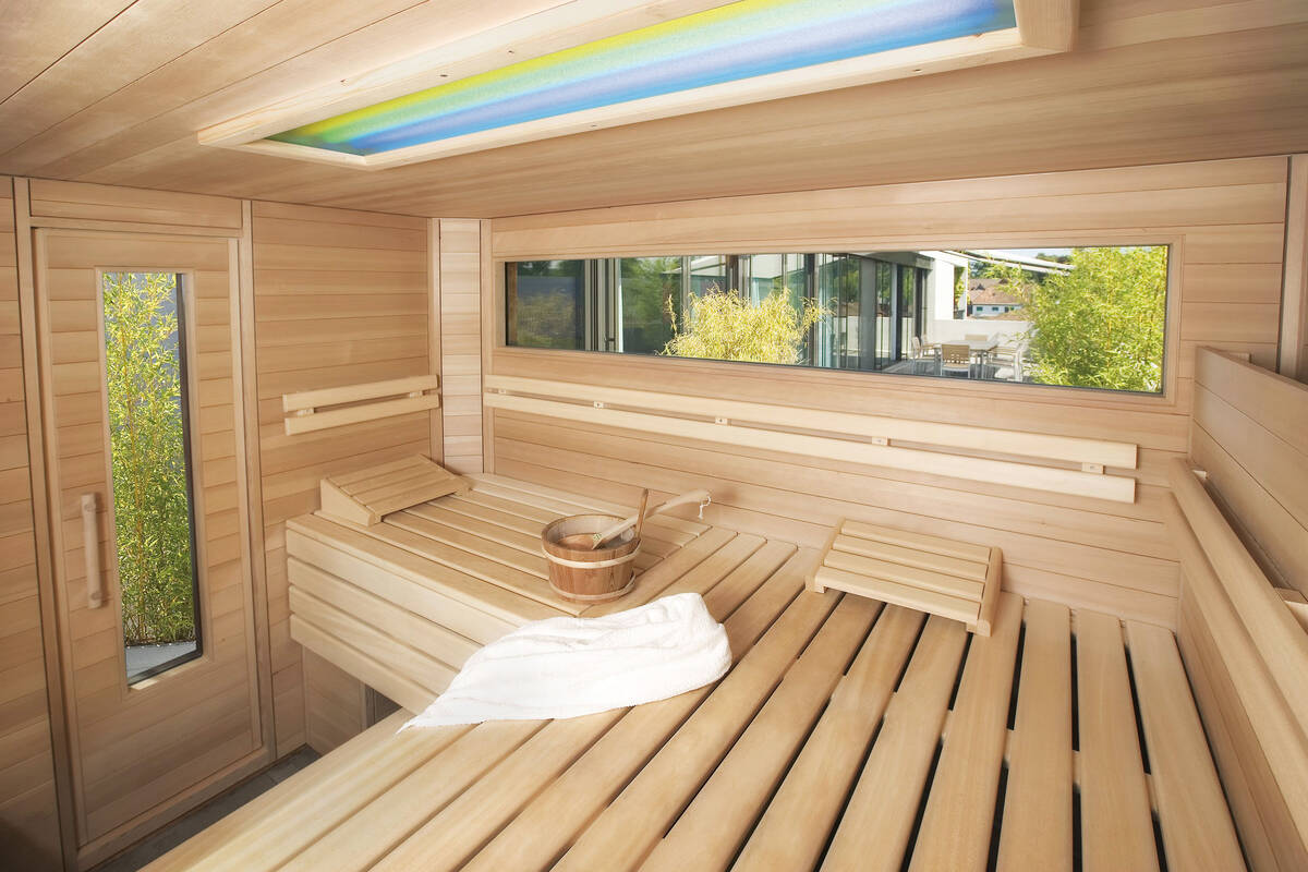 Von innen und aussen ein schöner Anblick: Auf die Terrasse abgestimmte Gartensauna von Fitness-Partner AG.