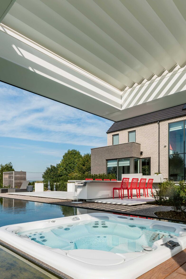 Drehbare Lamellen über dem Poolhaus regeln Licht und Schatten perfekt und schützen wenn nötig auch vor Wind und Wetter. «Algarve Roof», Renson, www.renson.eu