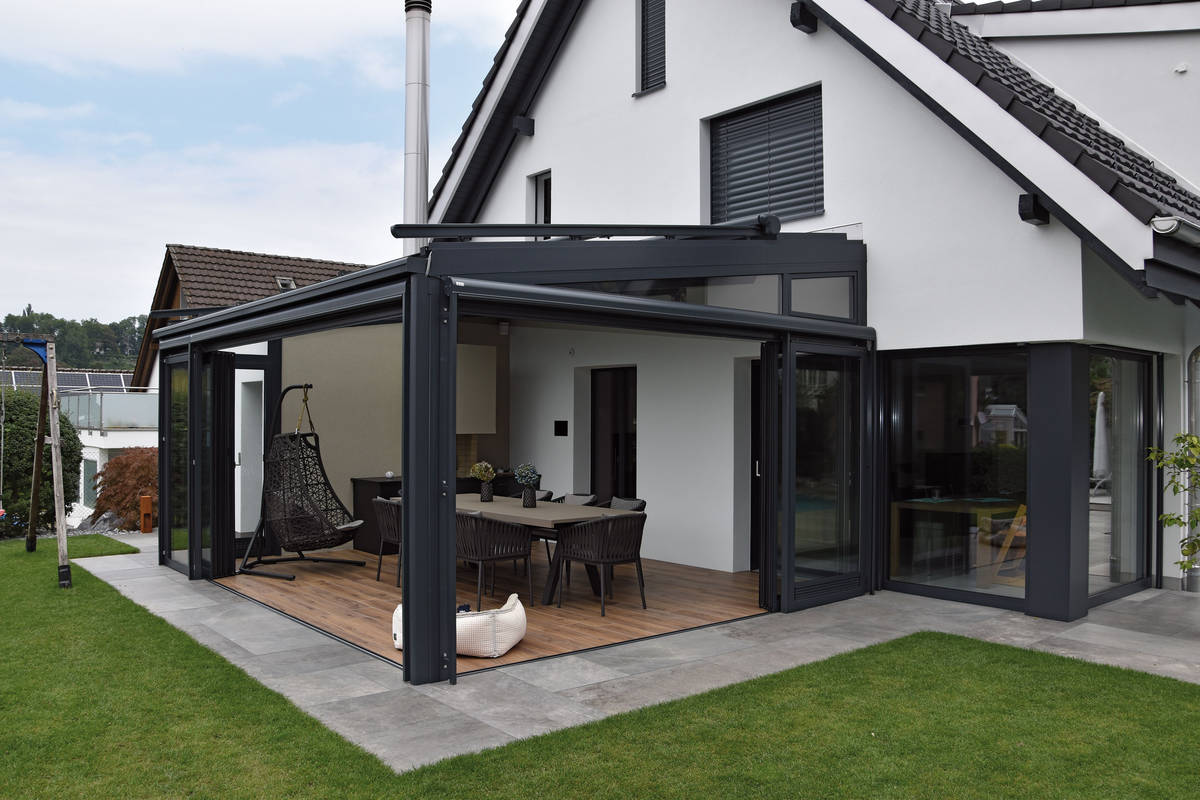 Der moderne Wintergarten mit Schiebe- und Rollwänden wird farblich passend zum Gebäude pulverbeschichtet. Durch leicht verschiebbare Glasflügel erreicht man eine maximale Öffnungsbreite. Movitec.