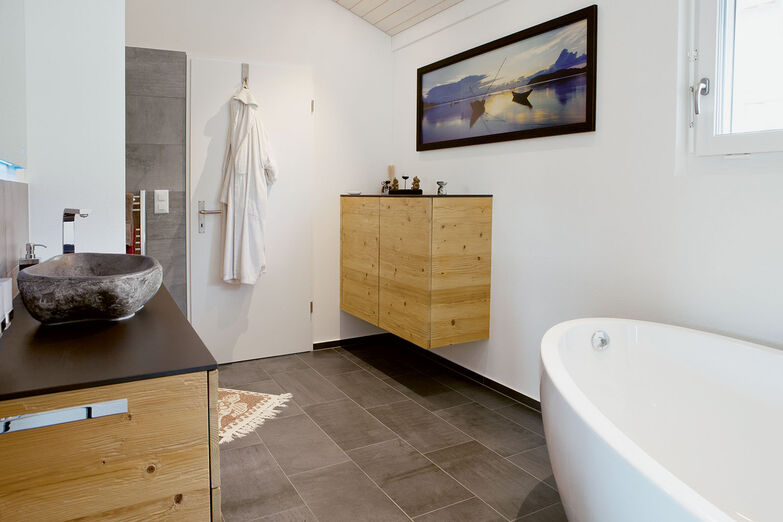 Im geräumigen und hellen Bad steht die Badewanne frei.
