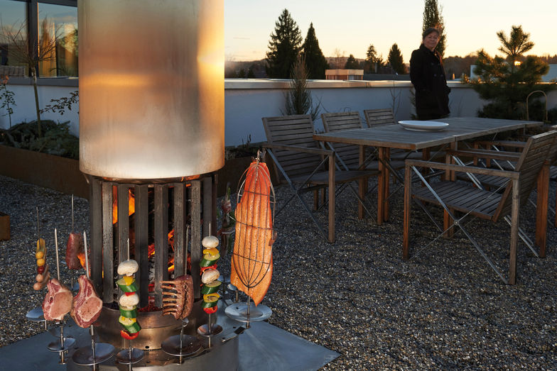 Das Schweizer Feuerrohr spendet nicht nur Wärme, sondern lässt sich auch als Grill nutzen.