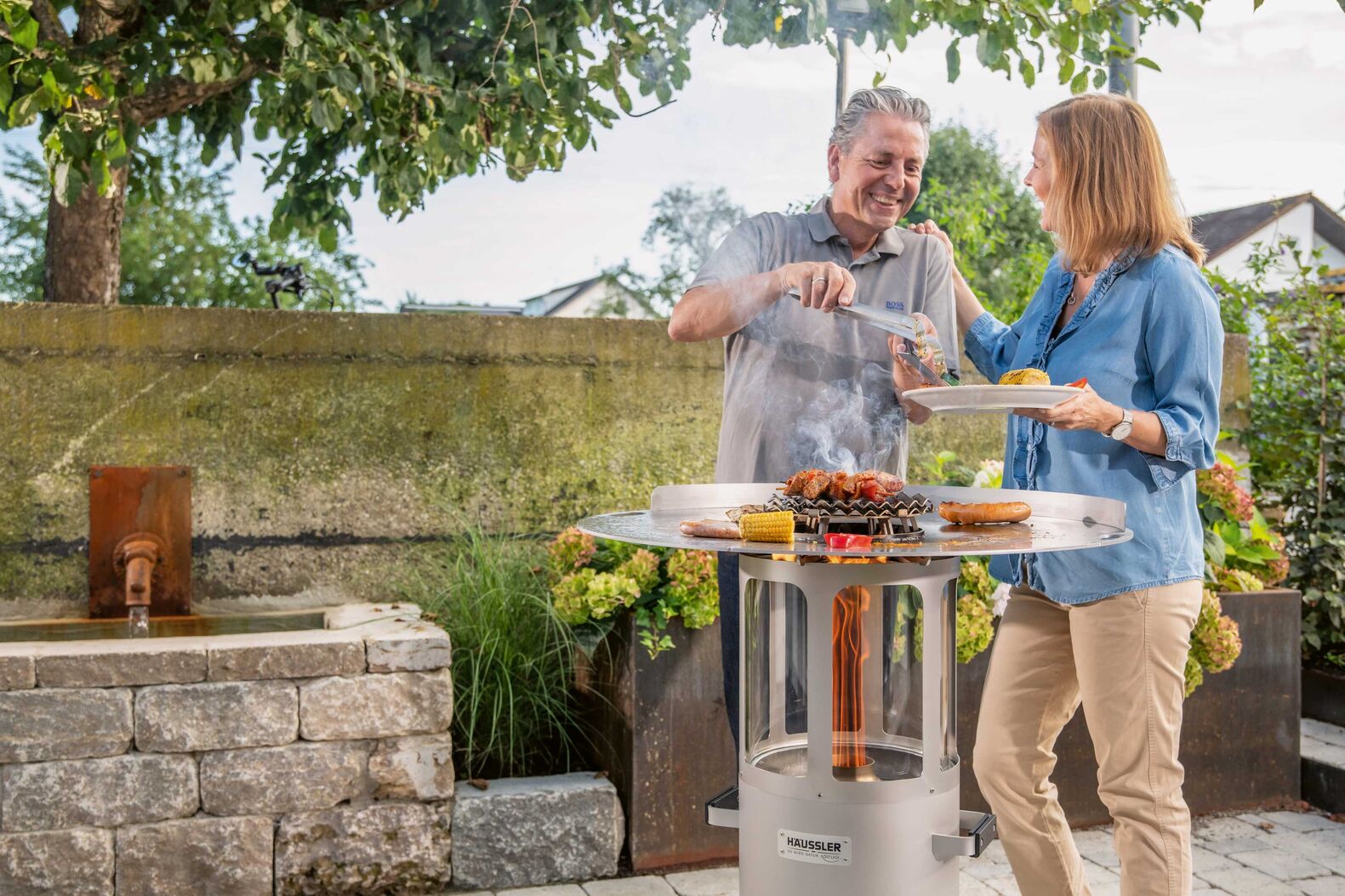 Dank Befeuerung mit Holzpellets ist der Edelstahl-Grill in wenigen Minuten grillfertig. Danach dient er als stimmungsvolles Ambientelicht. Häussler über Hein Feuerkonzepte GmbH.