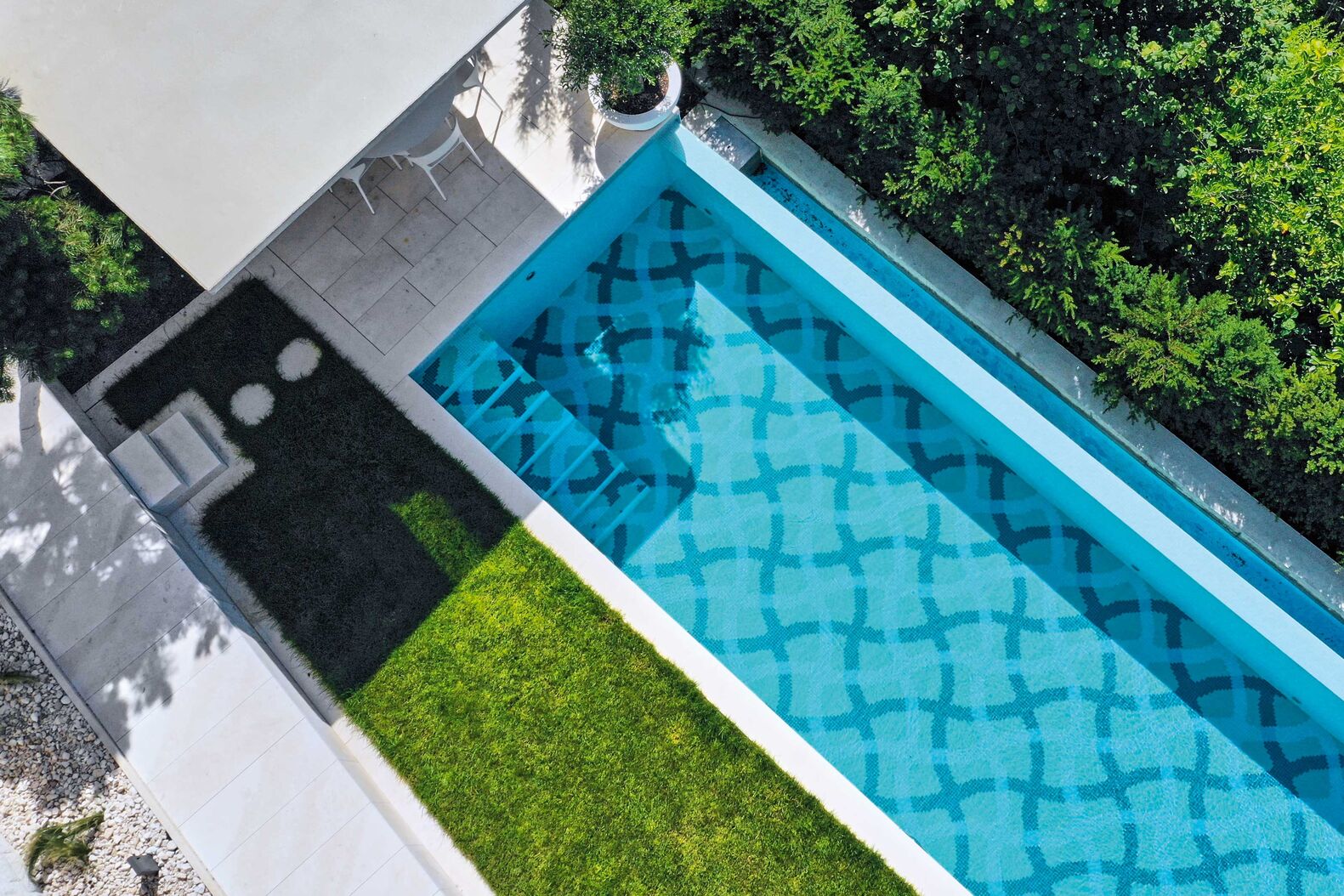 Marlin: Ein elegantes Schwimmbecken in Massivbauweise in der Grösse 11,0 x 2.80 m mit einseitiger Überflutung in ein offenes Ausgleichsbecken. Das Muster für die Mosaik-Auskleidung hat der Architekt Franco Pinazza eigens für diese Anlage entworfen. Eine integrierte Treppe führt ins warme Wasser. Die automatische Rollladen-Abdeckung ist elegant in einem Rucksackschacht verstaut. Drei LED-Leuchten beleuchten das Becken in warmweiss aus, und eine zweistrahlige Gegenstromanlage für sportliches Schwimmen ergänzt den Badespass. Die moderne automatische Schwimmbadtechnik ist mit einer hochwertigen Wasseraufbereitung eingerichtet und garantiert eine optimale Wasserqualität. Das Poolhaus rundet die Gartenbad-Anlage mit Nasszelle perfekt ab. www.marlin.ch