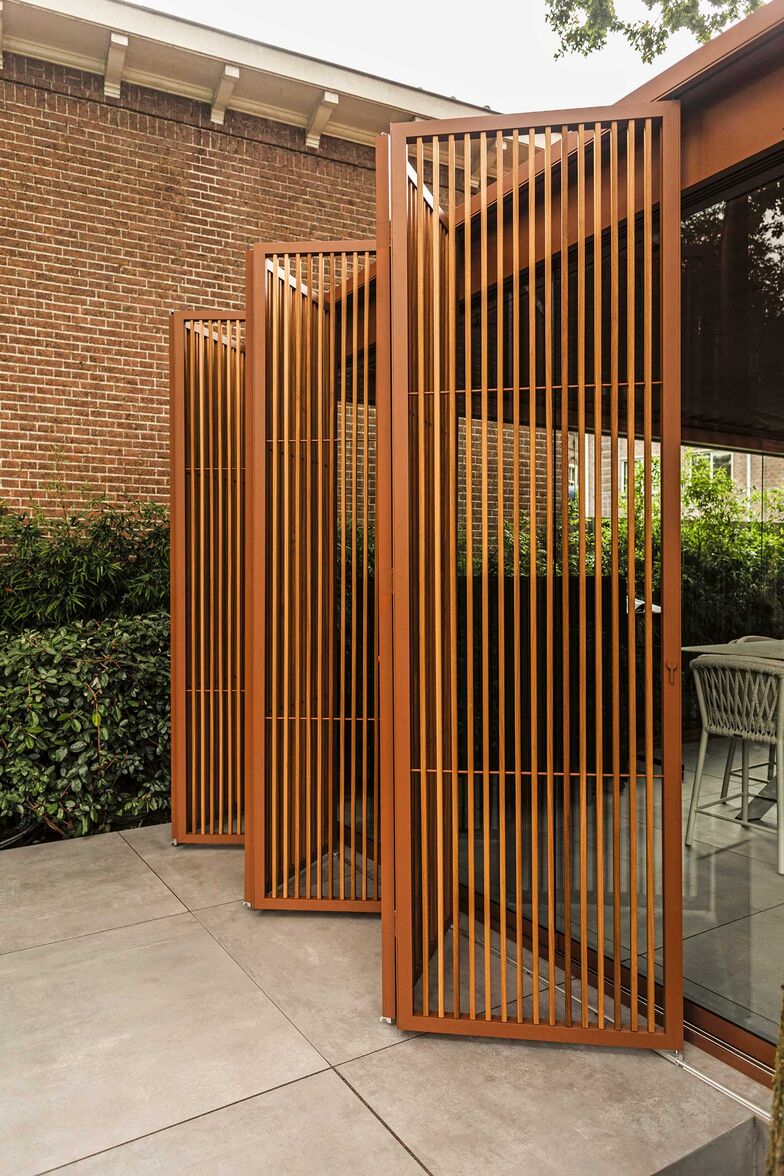 Wieso den Sichtschutz nicht gleich mit dem Sonnenschutz oder einer Überdachung kombinieren? Renson realisierte diesen Outdoorbereich. Die ruhigen Erdtöne und die natürlichen Materialien wirken elegant. Die klaren Linien strahlen Ruhe aus. Glasschiebetüren, Beleuchtungsarmaturen und faltbare Loggia-Paneele vervollständigen das Bild. www.renson.net