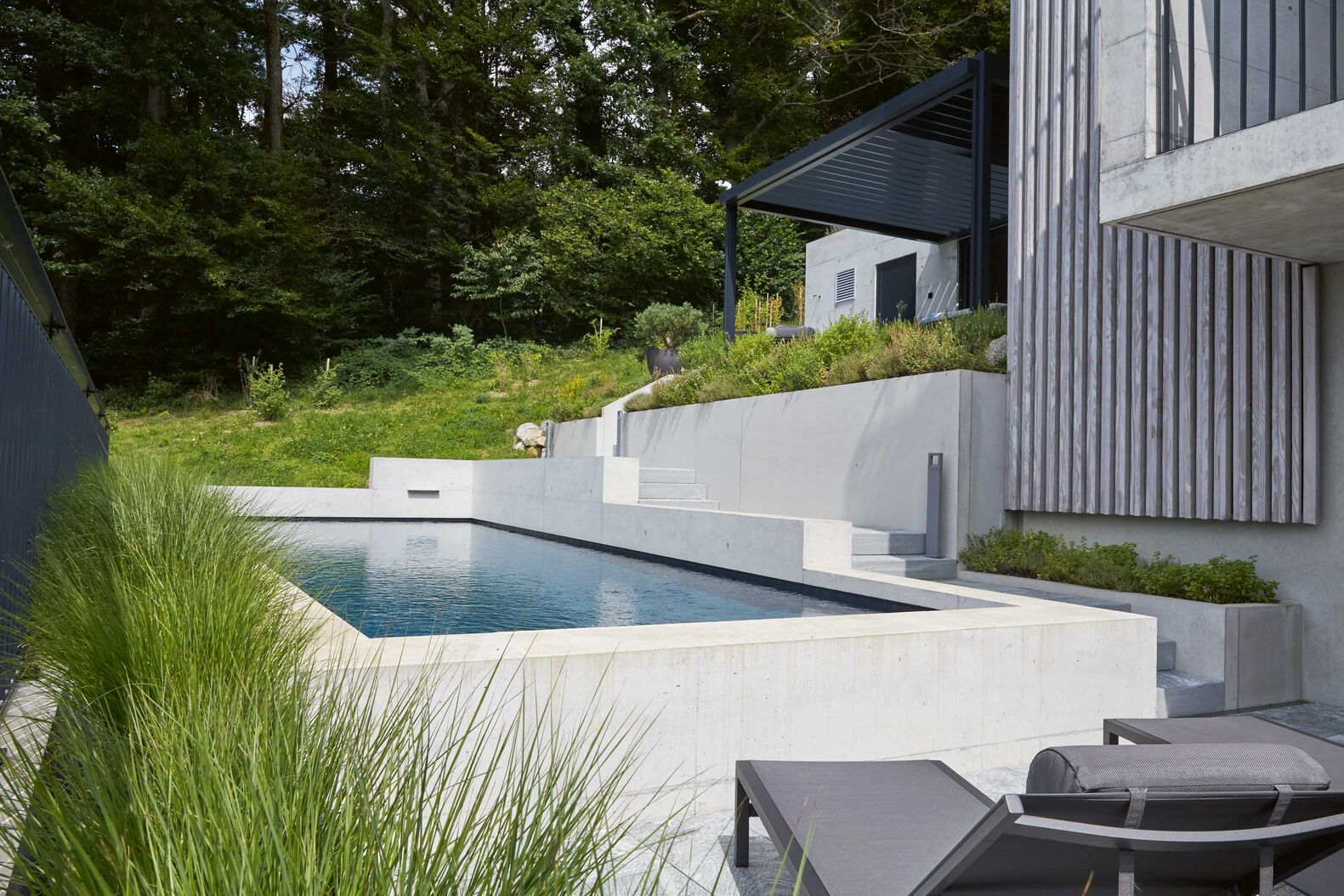 Der exklusive Betonpool misst 11,5 x 4 Meter und ist mit Düsen, Beleuchtung und einem Rollladen ausgestattet. Vita Bad AG, www.vitabad.ch