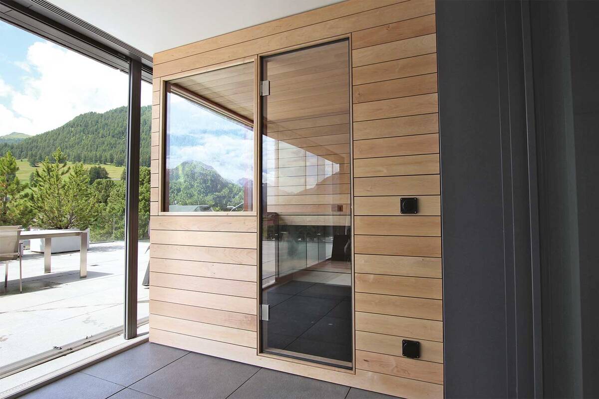 Die massgefertigte Sauna von Ging fügt sich präzise in die Loggia ein und nutzt den Platz optimal. Die passgenaue Planung ermöglicht die selbstverständliche Integration in die Architektur. Im Übergang von Innenraum zum Aussenbereich befindet sie sich in einem geschützten Rückzugsort, der dennoch den Blick auf die Landschaft zulässt. Ging Saunabau AG.
