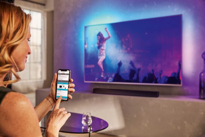 Das Smartphone ist allgegenwärtig. Mit ihm lässt sich auch per App das TV-Programm wählen. Philips.