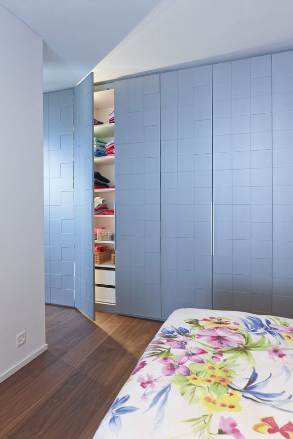 Mut zur Farbe: Der geräumige Schlafzimmerschrank bietet Platz für die gesamte Garderobe. Quadratische Tiefenfräsungen in der Wunschfarbe und die abgesetzten Griffprofile aus Aluminium lockern die lange Front optisch auf. Im Büro und Arbeitszimmer stehen Einbauschränke mit Fronten aus satiniertem Glas. Das Griffprofil erstreckt sich über die ganze Türhöhe.