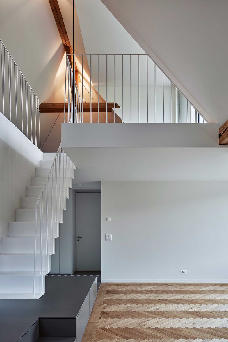 Filigrane, ans Sideboard angedockte Stahlfaltwerktreppe mit Staketengeländer aus Rundstahl. Entwurf: Ernst Gerber Architekten + Planer AG. Foto: Damian Poffet. Gyger Metallbau AG, www.gygertreppen.ch