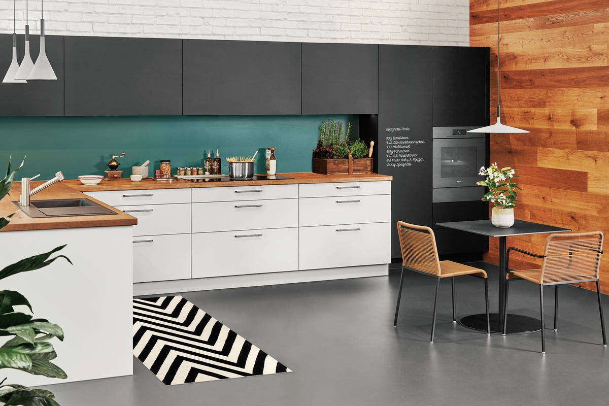 Mit Holz kombiniert, wirken die schwarz-weissen Küchenfronten nicht kühl, sondern urban und lebendig. Sabag.