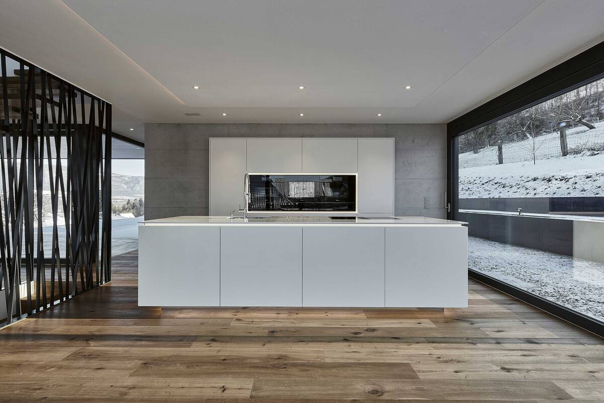 Die grifflosen Fronten unterstreichen den minimalistischen Stil der Küche. Bei der schwebend wirkendenden Arbeitsplatte handelt es sich um den Kunststein «Silestone Blanco Zeus». Furrer Küchen AG.