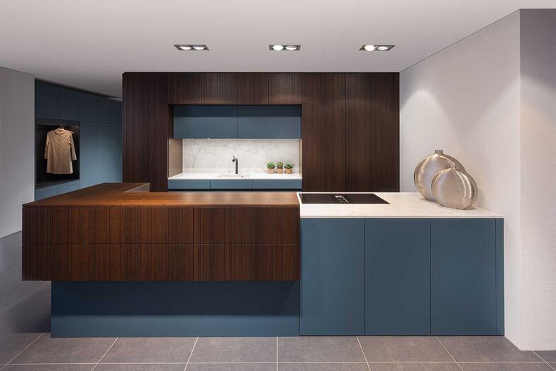 Ein Tupfer Farbe: Es muss nicht immer Schwarz und Weiss sein. Diese Showroom-Küche der Elbau Küchen AG besticht durch den geschickten Einsatz von Holz und Farbe sowie eine Ablage und ein Becken aus italienischem Naturstein. Die Küche kommt durch die raffinierte Farb-, Material- und Formkombination bei der Kücheninsel mit einer ausgeprägten Leichtigkeit daher. Die asymmetrische Rillenfront «Chilli» lässt Fugen unsichtbar wirken und betont den Charakter.
Elbau Küchen AG, www.elbau.ch